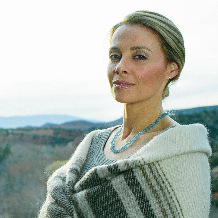 A woman wearing a crystal healing Aquamarine necklace known for heightening your awareness of truth