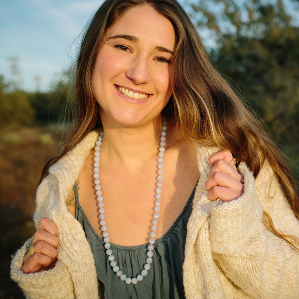 A woman wearing a crystal healing Blue Lace Agate necklace known for increasing confidence and self worth