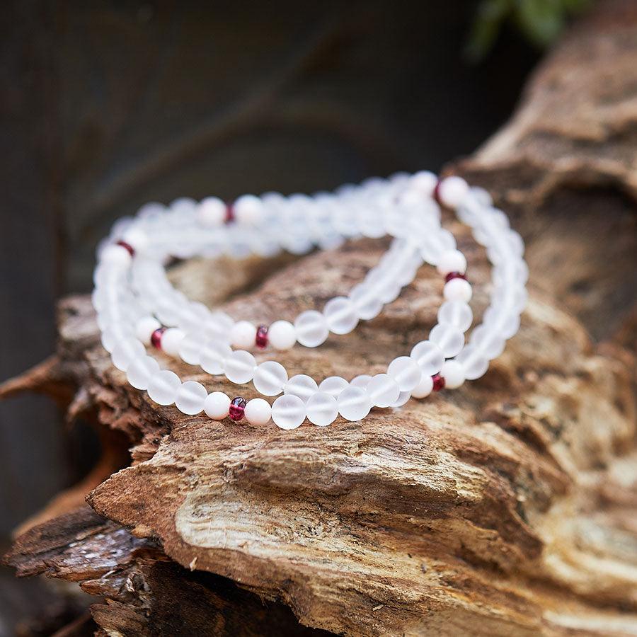 Crystal healing Dawn Light necklace known for Improving muscle strength laying on a piece of wood