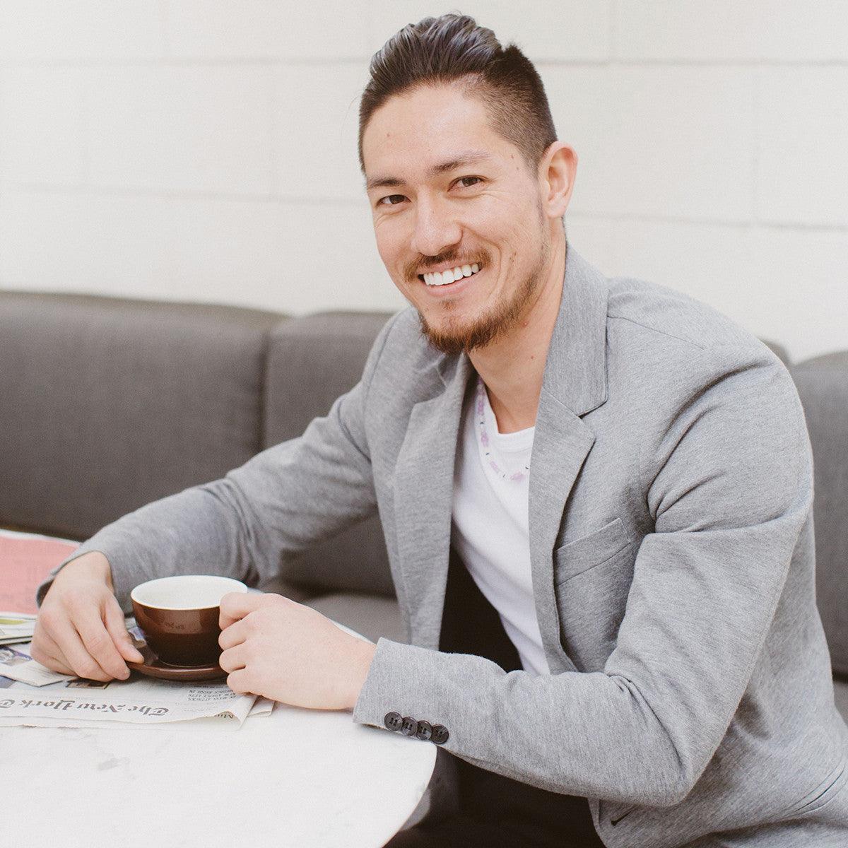 Man drinking coffee wearing a crystal healing Inner Quest necklace known for Improving mental focus