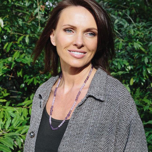 Woman wearing a crystal healing Insight necklace known for helping you understand the spiritual meaning of money