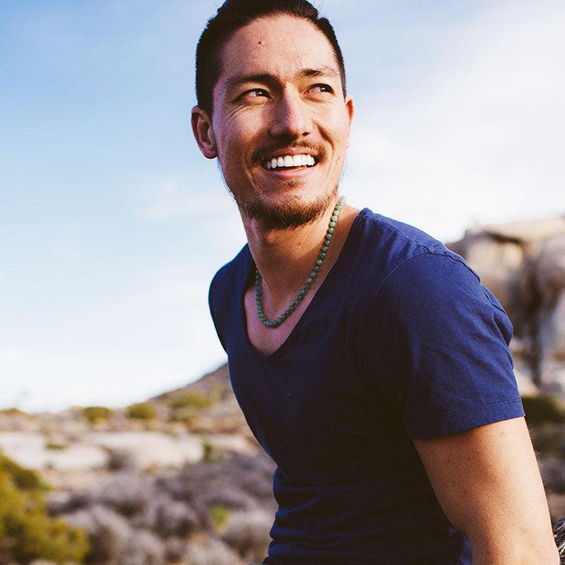 Man wearing a crystal healing Light Green Aventurine gemstone necklace known for uplifting your physical health
