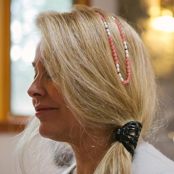 A woman wearing on her head a crystal healing Magic Gift gemstone necklace known for raising self-esteem and confidence