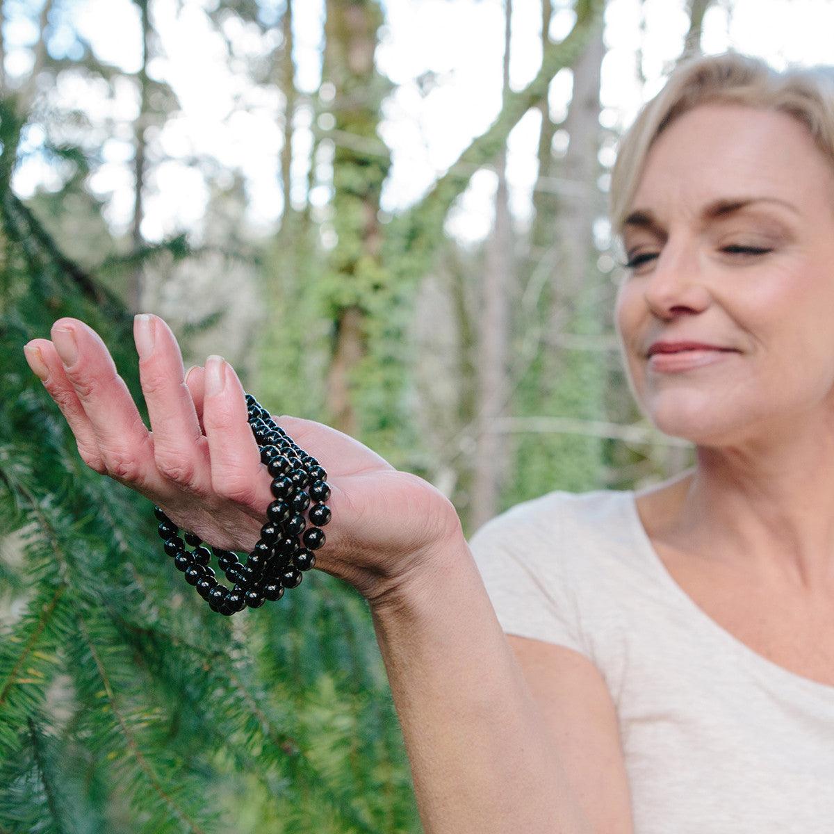 A woman wearing a crystal healing Onyx gemstone necklace known for helping one become grounded and focused