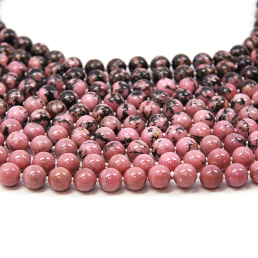 A row of Crystal healing Rhodonite gemstone necklaces for emotional transformation 