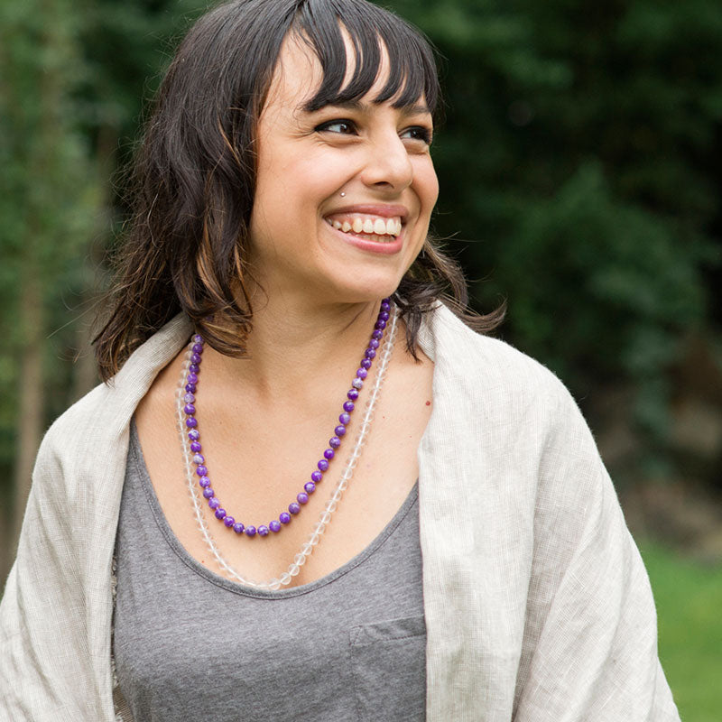 Woman wearing a crystal healing Sugilite gemstone necklace known for clearing toxic energies