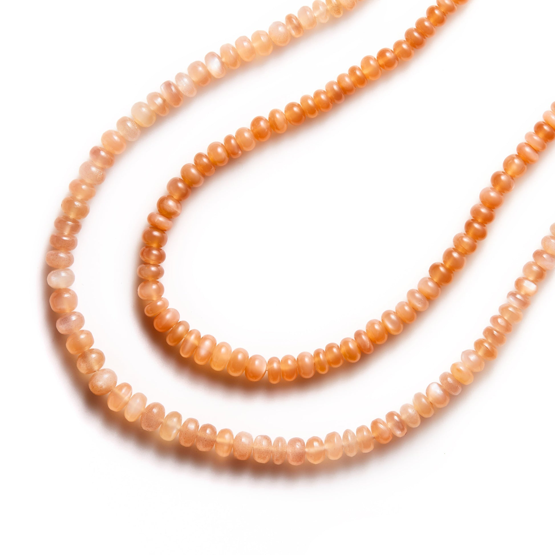 Two crystal healing Peach Moonstone necklaces on a white background for peace and rejuvenation