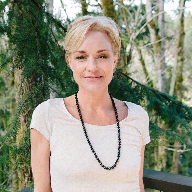 A woman wearing a crystal healing Onyx gemstone necklace known for helping one become grounded and focused