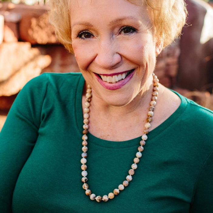 A woman wearing a crystal healing Opalight gemstone necklace known for resolving the karmic causes of a physical condition
