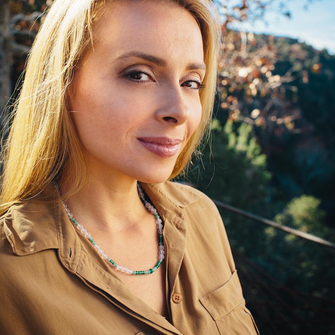 A woman wearing a crystal healing Summer necklace known for supporting organ health