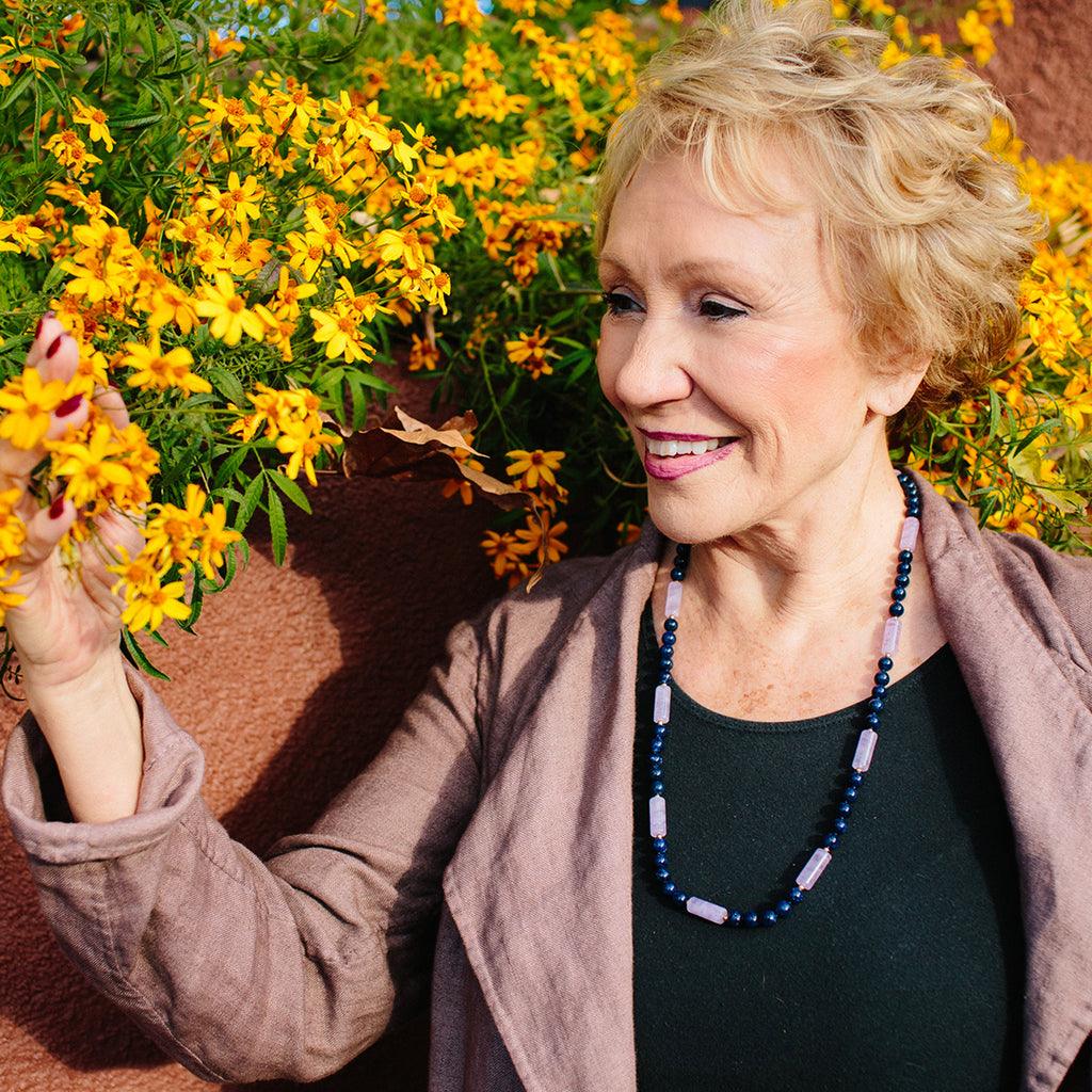 A woman wearing a crystal healing Lavender Light gemstone necklace known for giving joy, wisdom, and inner guidance