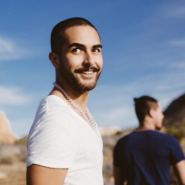 A man wearing a crystal healing Quartz gemstone necklace known for attracting life-force to the wearer