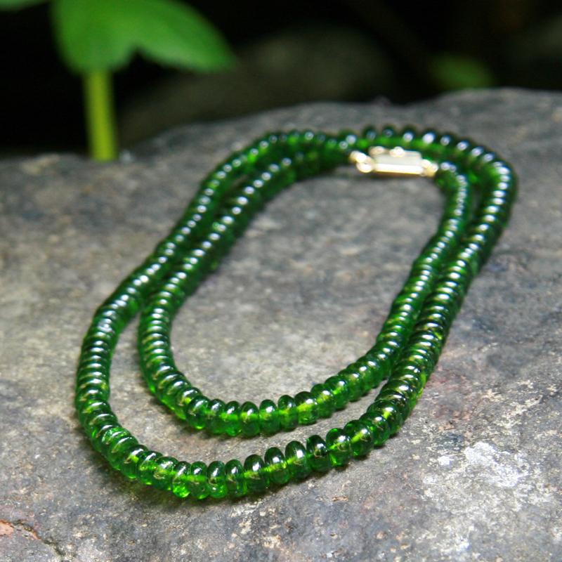Crystal healing Chrome Diopside necklace lying on a rock known for awakening your healing wisdom and power 