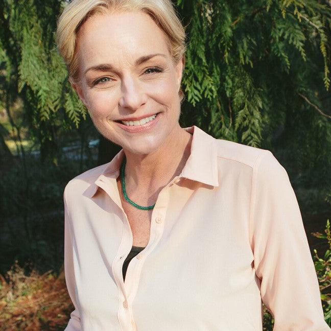 A woman wearing an Emerald necklace known for physical healing