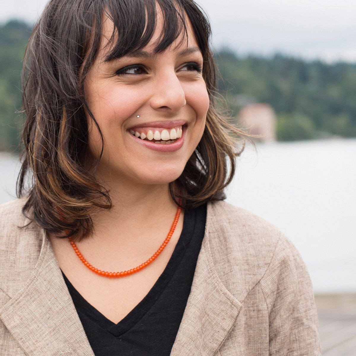 A woman wearing a crystal healing Precious Carnelian necklace known for increasing optimism, vitality, joy