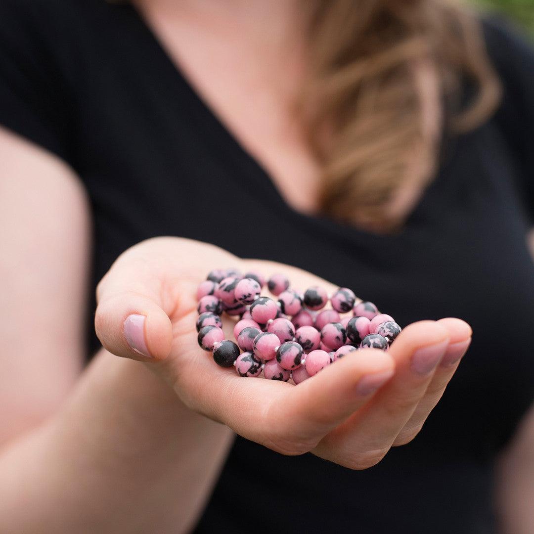 Crystal healing Rhodonite gemstone necklace known for fostering emotional strength and stability