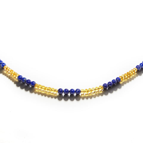 Yellow and blue Golden Phoenix gemstone necklace displayed on a white table.