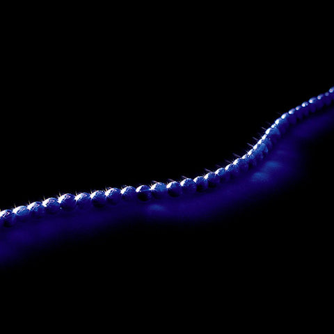 Purple indigo gemstone necklace displayed on a black table.
