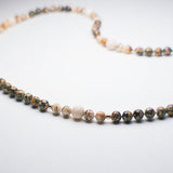 Leopard Magic therapeutic gemstone necklace displayed on a white table.