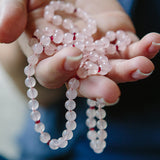 Ruby Rose therapeutic gemstone necklace being held between a woman's hands.